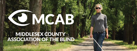 Logo of the Middlesex County Association of the Blind: A stylized eye drawing on the left with 'Middlesex County Association of the Blind' captioned under the eye. On the right, a woman wearing a grey turtle neck shirt and dark blue jeans is walking on a gravel trail in a wooded area using a white cane.